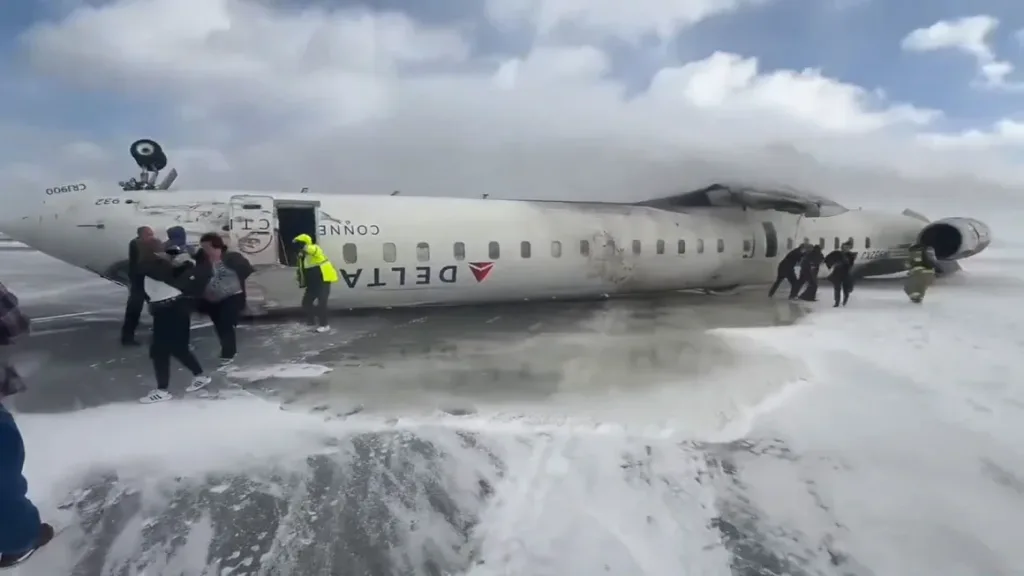 "Image of Delta Flight 4819 overturned on the runway at Toronto Pearson Airport, with emergency crews responding to the crash scene."